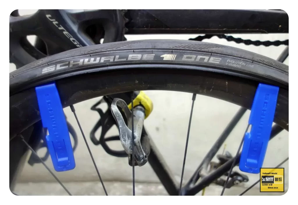 타이어 주걱을 사용해 자전거 바퀴의 타이어를 분리합니다.